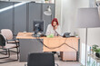 © Oscar - female receptionist sitting at desk making phone calls
