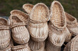 Straw-woven bast shoes lie on the counter. Eco-friendly handmade products. Ukrainian traditional handcraft. 