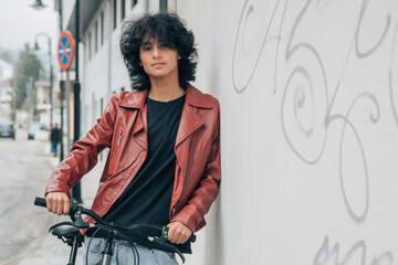 Wall Mural - young latin hispanic man with bike on the street