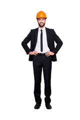 Canvas Print - Full length size portrait of attractive cheerful joyful investor in orange hard hat and black tuxedo with tie, looking at camera, isolated on grey background, holding two arms on waist