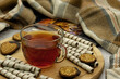 Tea, dessert and blanket. A cup of tea, nut cookies, a book and a warm blanket create coziness. Tea in cold weather.