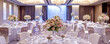 une grande salle à manger de mariage décorée avec des fleurs et des drapés blancs