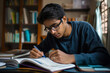© Татьяна Евдокимова - Focused Indian student organizing and taking notes from his textbooks in a study session