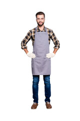 Wall Mural - Full size body portrait of attractive cheerful carpenter with hairstyle in safety glasses, jeans, looking at camera holding his two arms on waist isolated on grey background