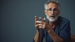 © PaulShlykov - Senior man with public speaker gesture. Fingers connected at fingertips, pose which imposes power and patience, gray studio background, copy space