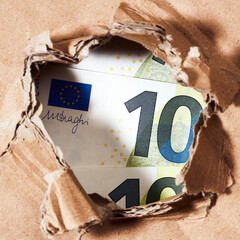 Wall Mural - one hundred euro banknote through the hole in paper background