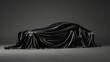 Presentation of a car covered with a black cloth on a dark gray background. Concept car