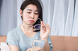 Asian woman have eye blur vision hand holding eyeglasses try to read mobile phone screen