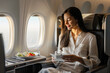 refined luxury of the business class cabin on an airplane, as experienced by a young woman, with spacious seating and attentive service, against a backdrop of polished interiors an