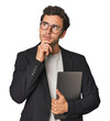© Asier - Young Hispanic businessman with laptop looking sideways with doubtful and skeptical expression.