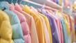 An assortment of pastel-colored jackets neatly displayed on a clothing rack in a retail shop.
