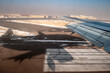 Landung oder Start eines Flugzeugs aus Sicht eines Passagiers mit Piste, Schatten des Flugzeugs und Häusern des Airports mit Bewegungsunschärfe