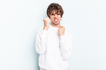 Wall Mural - Young caucasian man isolated on blue background upset screaming with tense hands.