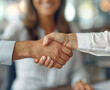 Close-up of business people shaking hands while standing in office.