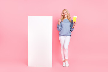 Wall Mural - Full length photo of young pretty lady indicate finger mobile reservation tourism trip select isolated over pink color background