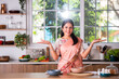 Portrait of happy Indian asian young woman wears saree while working in kitchen