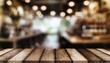 Wooden Table in Focus with Blurred Coffee Shop Background