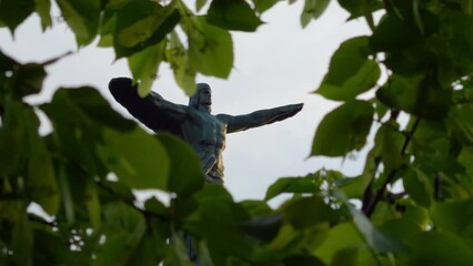 Wall Mural - Aviatorilor statue. Landmark of Bucharest located on Aviatorilor Boulevard, view through the green tree leaves. Travel to Romania. Vertical photo.