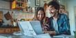 © LukaszDesign - Beautiful young lady behind her husband working on his laptop while they smile at the screen. Happy young interracial couple working from home and surfing the web.