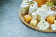 Several types of cheese served with honey and grapes