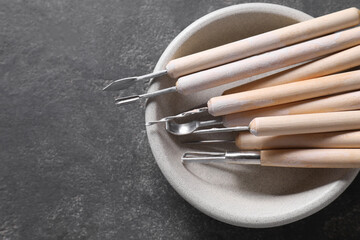 Sticker - Set of different clay crafting tools on grey table, top view. Space for text