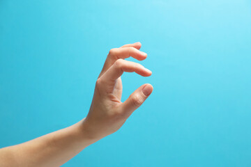 Wall Mural - woman holding something in hand on light blue background, closeup