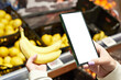 Banana in store and smartphone isolated white