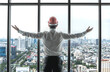 © Jack Tamrong - Back view engineer man standing and looking out of high rise office windows