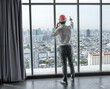 © Jack Tamrong - Back view engineer man standing and looking out of high rise office windows
