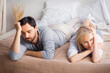 Unhappy sad couple, brunette bearded man, woman, husband wife lay on bed at bedroom turned away from each other. Unlove crisis, sexual problem issues, relationship crisis, divorce  conflict - concept.