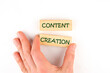 © Ihar - Concept word Content creation on wooden blocks made up by human hand on a white background