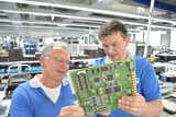 Fototapeta  - teamwork in a modern industrial factory - group of workers in the production and development of electronics