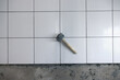 Tile floor under construction at interior. Include mallet tool, concrete mortar cement and white square ceramic tile. Finishing material for decor surface in bathroom, kitchen and shower room.