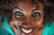 Close up of an African American woman with blue eyes looking excited and joyful, smiling broadly