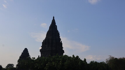 View of a temple in ancient Prambanan temple complex with clear blue sky background. Popular tourist destination. No People.