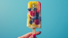 A Playful Hand Holds A Brightly Colored Popsicle Bar With Fruit And Berries, Perfect For An Appealing Photo Ad, On A Crisp Isolated Background, Studio Lighting