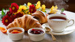 photo french breakfast with croissants, apricot jam, cherry jam and a cup of tea, red and yellow flowers