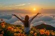 © BrightWhite - Glorious view of woman enjoying sunset over sea of clouds amid vibrant orange flowers, prompting feelings of freedom and rejuvenation, ideal for spring and summer vibes.