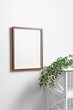 Blank picture frame mockup with copy space for design on white wall with eucalyptus twigs
