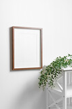 Fototapeta Lawenda - Blank picture frame mockup with copy space for design on white wall with eucalyptus twigs
