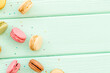 Brignt macarons for sweet break on mint green background top view mock up