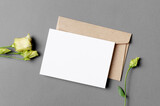 Fototapeta Lawenda - Wedding invitation card mockup with envelope and flower, top view with copy space
