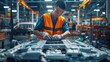 Asian worker wearing an orange vest is looking at a battery for an electric car