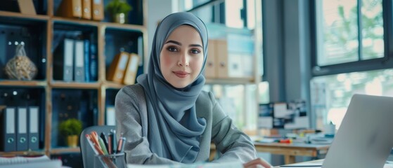 Poster - The image shows a Muslim woman wearing hijab working on an engineering project, analyzing documents and blueprints. An empowered digital entrepreneur works on an e-commerce project with her team.