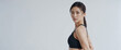 © Roman - Young asian fit sexy woman standing isolated on a gray background. Studio portrait of a healthy muscular female.