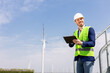 © BGStock72 - Smiling Engineer With Tablet Inspecting Wind Turbines On A Sunny Day