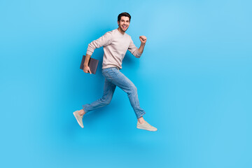 Aufkleber - Full size photo of optimistic cheerful man wear sweatshirt denim pants run to empty space with laptop isolated on blue color background