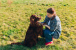 © mdyn - Cheerful happy young woman playing with her dog in the yard in summer. Beautiful Irish Setter dog is lying in grass. Pets adoption, care and love concept