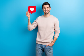 Poster - Portrait of nice young man hold paper like notification card wear beige sweatshirt isolated on blue color background