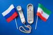 Old telephone and flags of Russia and Iran on a blue background, concept on the theme of telephone conversations between countries